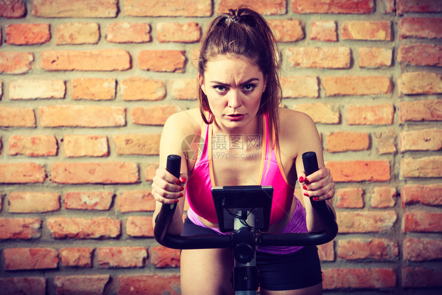 健身房运动车中心运动女生训练瘦身减肥概念运动妇女骑自行车图片