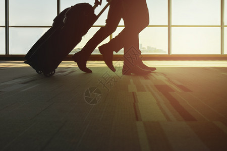 旅客提着行李在机场行走图片