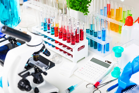 医药发展论坛创意抽象化学发展医药生物学化和研究技术概念带有科学化实验室设备的表格显微镜带有色液体物质样本的测试管瓶报告文件等有选择焦点效果背景