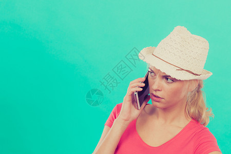 国际电话打给外朋友和家人现代技术概念用太阳帽在电话上交谈的女游客迷惑图片