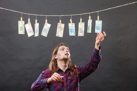 货币兑换概念人工检查货币现金付款挂在洗衣线上人核查货币现金图片