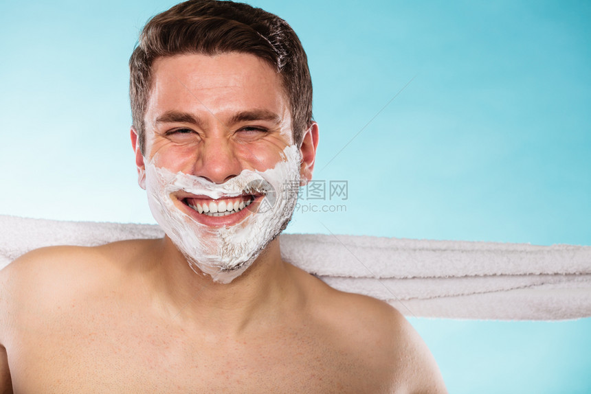 带着剃须奶油泡沫和白毛巾的快乐年轻人准备刮胡子的帅哥皮肤护理和卫生带着剃须奶油泡沫的快乐年轻帅哥图片