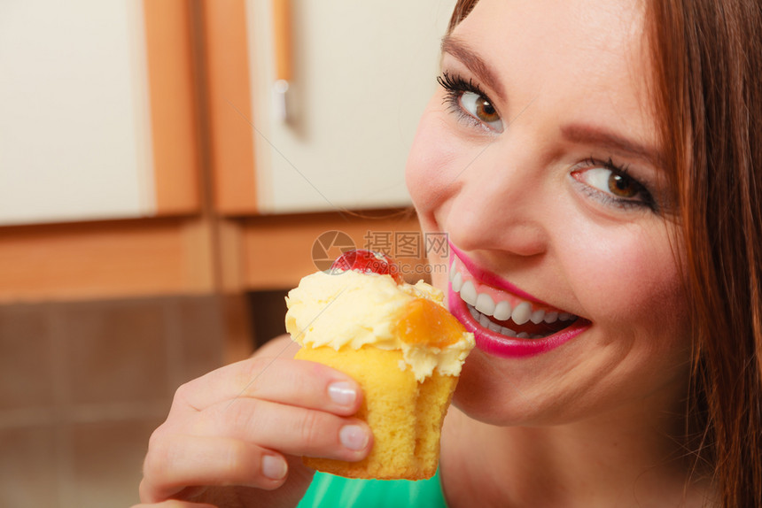 女人吃美味的蛋糕上面有甜的奶油和水果图片