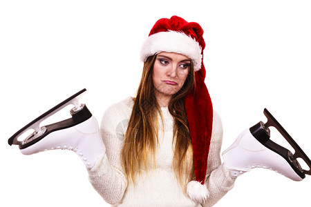 冬季滑冰运动者概念女孩有圣塔克拉斯帽年轻女有白色服装和长的漂亮头发女有两只冰鞋女孩有圣塔克莱斯帽背景图片