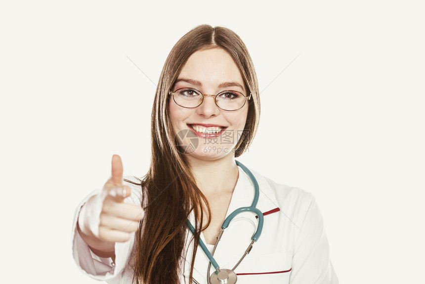 带着白大衣微笑容的女医生戴着听诊器白大衣指你专业保健援助孤立在白色上用听诊器指着你用听诊器指着你的女医生图片