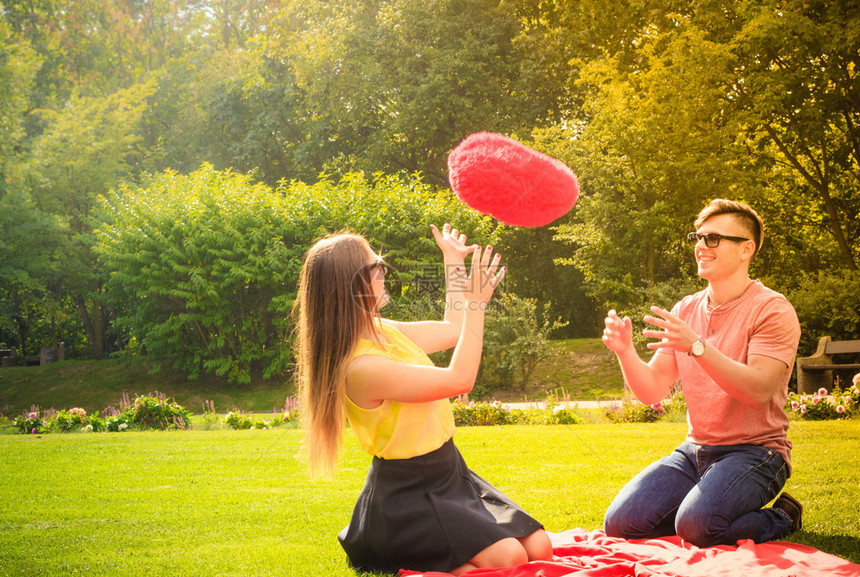 爱和约会年轻时尚的情侣在公园玩得开心与红一起在公园里图片