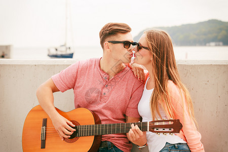 女友亲吻在户外弹吉他的男友图片