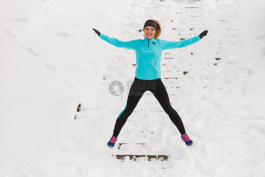 年轻女孩穿着运动服在雪地中锻炼图片