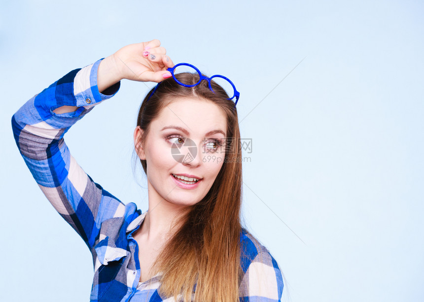 有吸引力的书呆女头戴奇怪的大眼镜工作室拍到蓝背景头戴奇怪眼镜的书呆女图片