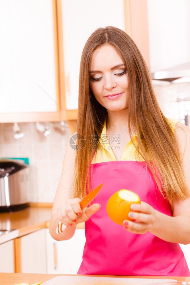 家中厨房的年轻女家庭主妇为沙拉或多汁而剥橙子水果健康饮食烹饪生品饮和人的概念图片
