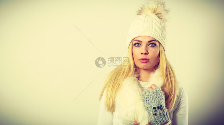 冬季时身着装的冬季白毛围巾羊帽和手套的金发年轻女子工作室中弹身着温暖冬季服装的妇女图片