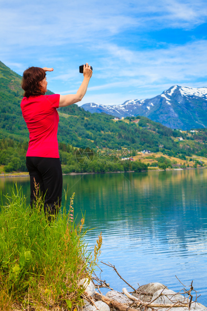 旅游和行女游者与照相机拍在Jostedalsbreen公园StrynSognogFjordane县挪威斯堪的纳维亚州Oppstr图片