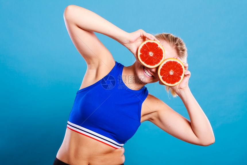 将两半的葡萄果柑橘握在手中遮住眼睛健康饮食品节假日快乐的概念图片