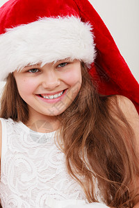 快乐可爱的小女孩穿着红圣达克萨斯帽子圣诞快乐的小女孩背景图片