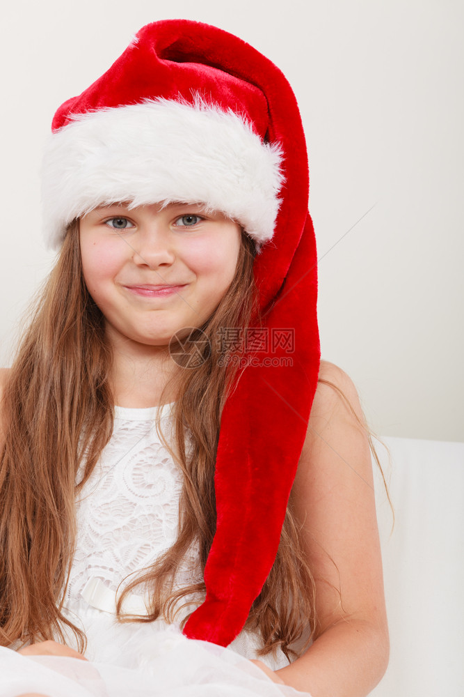 快乐可爱的小女孩穿着红圣达克萨斯帽子圣诞快乐的小女孩图片