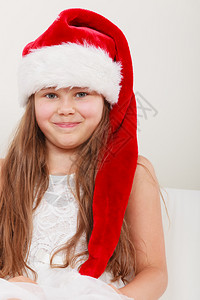 快乐可爱的小女孩穿着红圣达克萨斯帽子圣诞快乐的小女孩背景图片