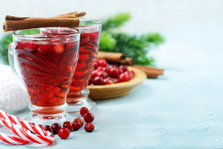 红莓酒和浆果圣诞节喝在玻璃和桌子上高清图片