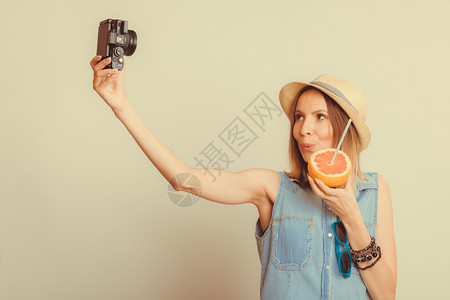 穿着草帽的观光女乘着照相机拍自暑假Instagram过滤女用相机拍自图片