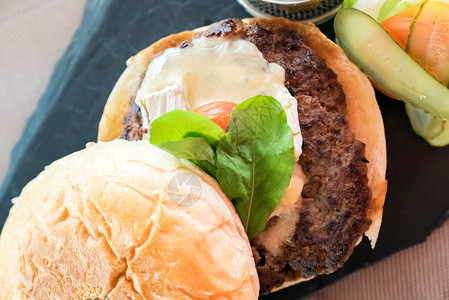 土制超重牛肉汉堡包配新鲜蔬菜和奶酪薯条图片