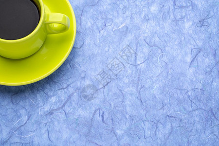 黑色咖啡杯与蓝手工造木莓纸相比带有复制空间图片