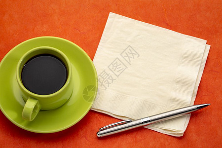 抽象颜色绿咖啡杯配有餐巾纸和笔的咖啡杯与红毛莓纸相对图片