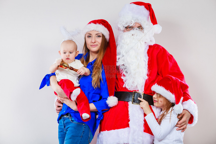 穿着圣诞老人服装的父母和两个女儿的家庭照片图片