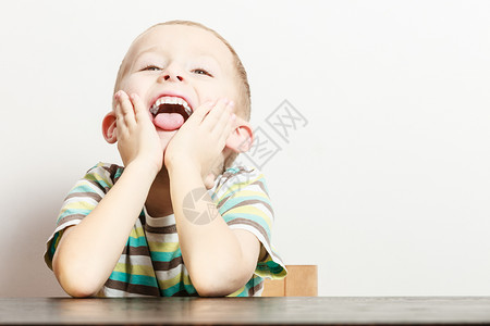 小男孩在室内玩耍时会做傻的手势面对情绪图片