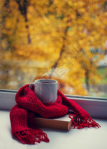 咖啡和围巾秋天的生命温暖围巾和茶杯靠近窗户背景
