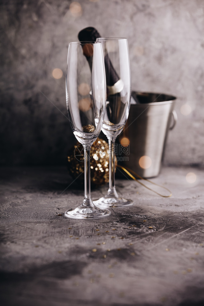 香槟瓶装有冰眼镜和圣诞装饰放在灰石背景上香槟瓶图片