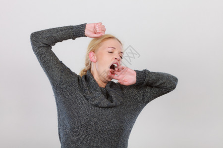 疲倦睡觉时间概念沉睡打哈的女人在自我伸展打哈的妇女在伸展手臂图片