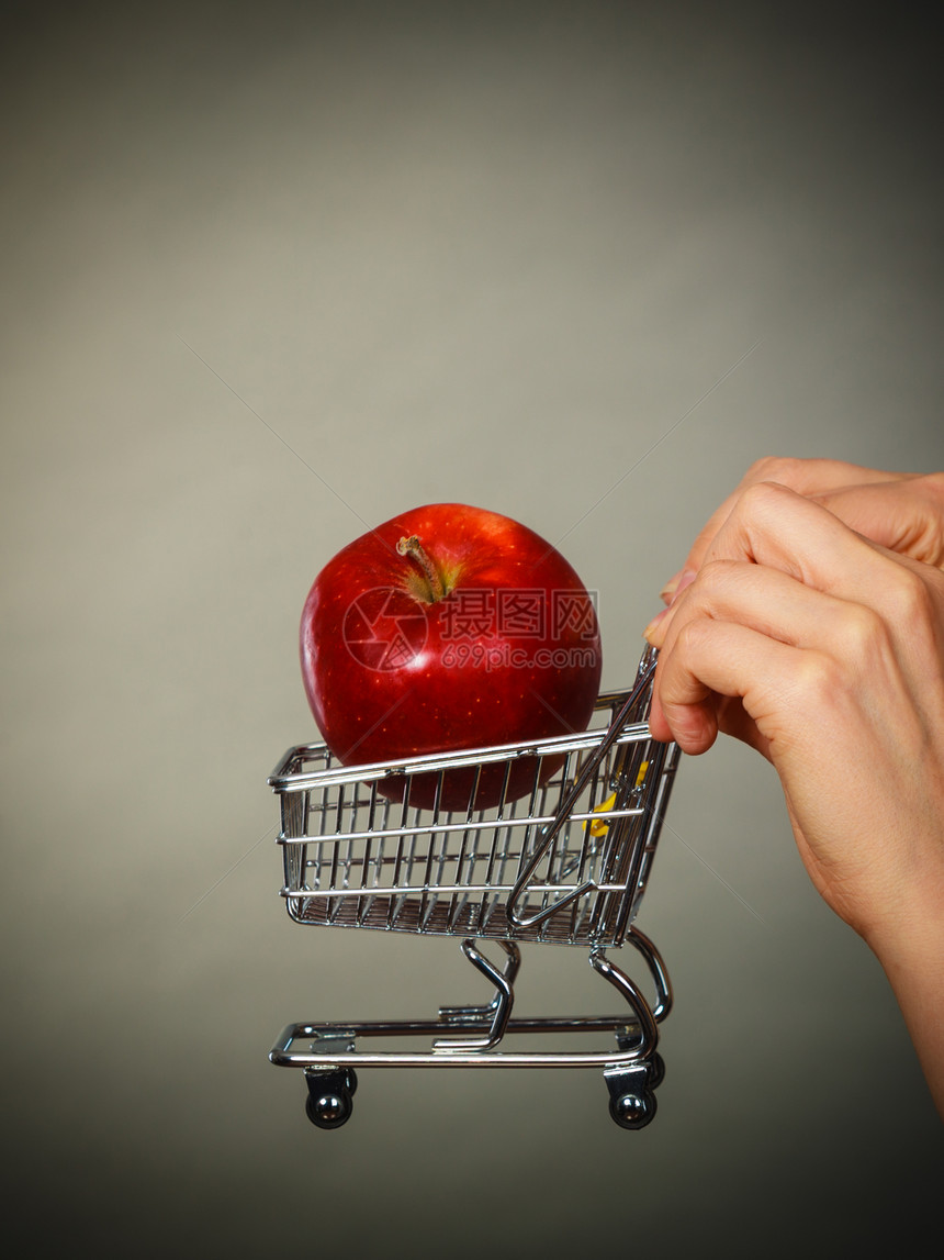 购买健康食品素无用等素制产品妇女拿着内装苹果的购物车图片