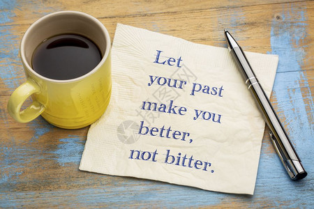 让你的过去变得更好而不是苦笔迹在餐巾纸上与一杯咖啡背景
