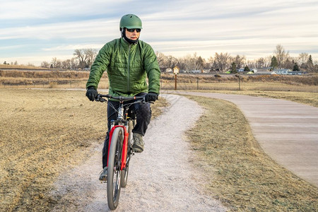 在科罗拉多北部林斯堡一个典型的冬季风景中新建的自行车足迹上成年骑手图片