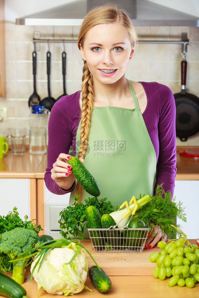 购买健康的饮食品概念厨房里的妇女有许多绿色蔬菜手持小购物篮车厨房里的妇女手持蔬菜篮子厨房里的妇女手持蔬菜篮子图片