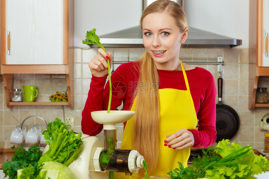 厨房里的年轻女用绿色蔬菜制成健康的蔬菜冰淇淋汁厨房里的女用蔬菜汁制成冰淇淋汁图片