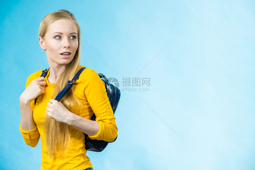 穿着时装背包上学或大的金发少女穿着时装背包上学或大配有时装饰品穿蓝色带背包的少女图片