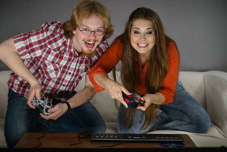 快乐的情侣通过一起玩电子游戏享受休闲时间背景图片