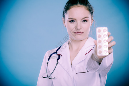 治疗方式白色外形围裙显示药片的剂医生有听诊器的女专家持有药物剂的师图片