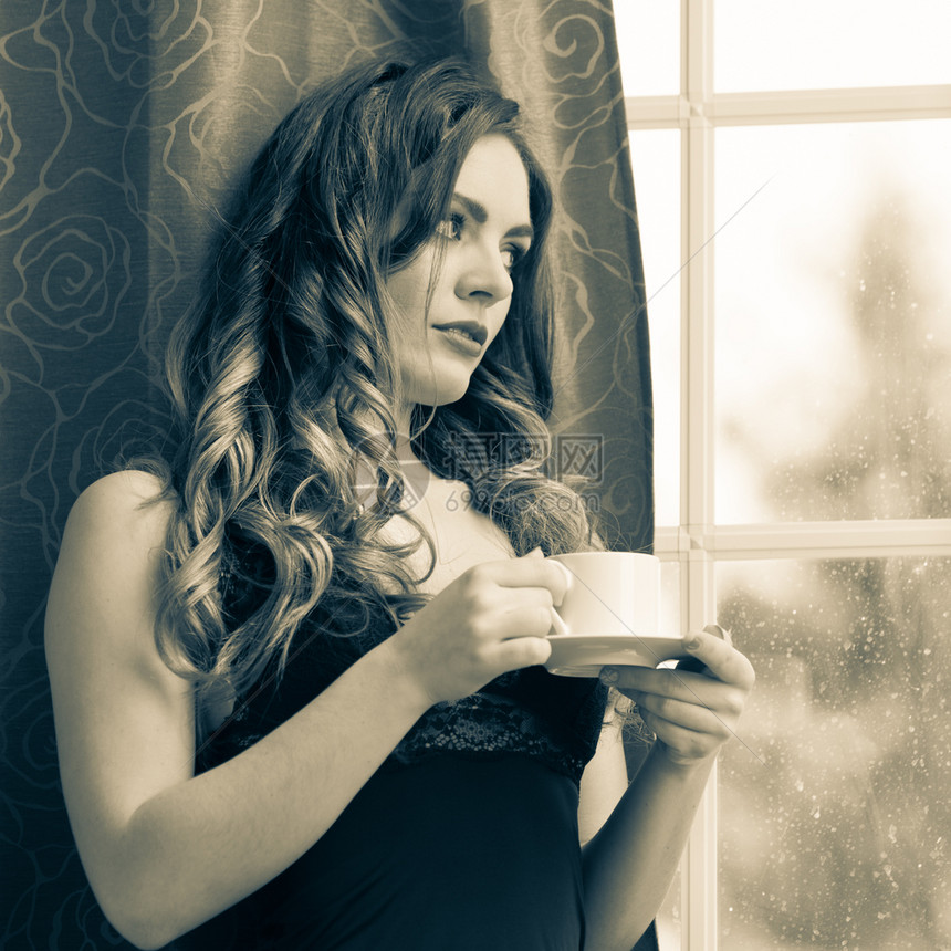穿着内衣的感女人在家用窗帘和法国门喝咖啡着热汽水的年轻女孩保持清醒咖啡能黑人和白感女在家里喝着热咖啡饮料图片