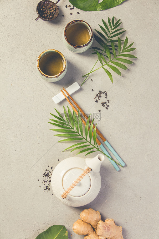 亚洲食品背景灰水泥背景上的茶和筷子顶端视图平板亚洲食品背景茶和筷子灰水泥背景上图片