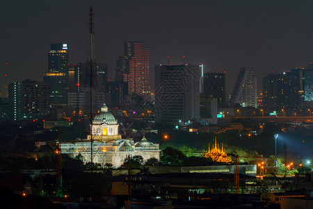 在泰国曼谷市内夜里安南塔萨马卡姆王座和摩天大楼背景