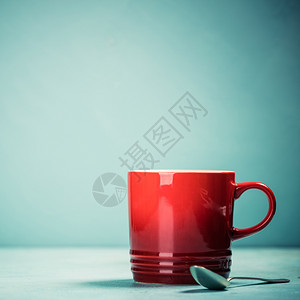 蓝色背景的红咖啡杯或茶蓝色背景的红杯文本空间背景图片
