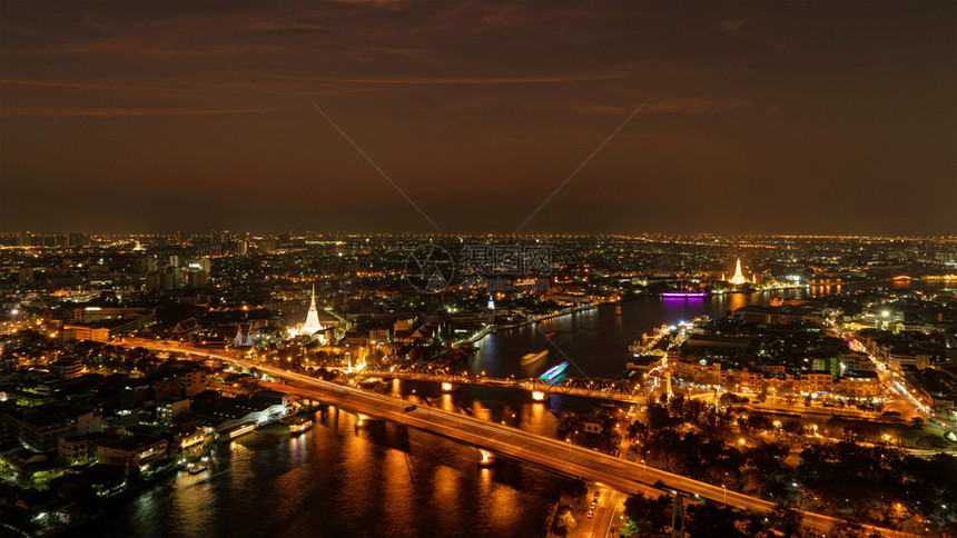 WhitePrayoonPagoda纪念桥和PhraPokKlao桥夜间有ChaoPhraya河的建筑物和曲线泰国曼谷市下城图片