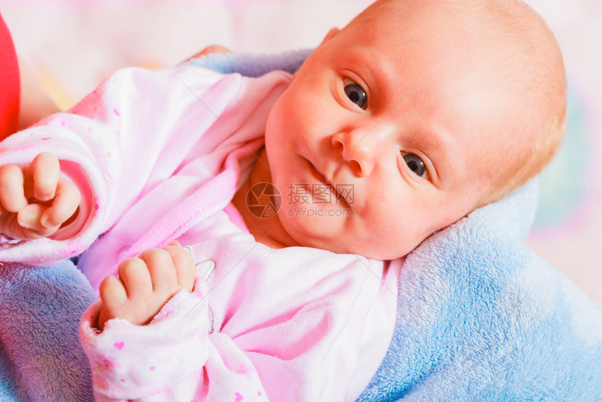 穿着睡衣躺在背面的小新生儿部表情家庭父母儿童概念新生小婴图片