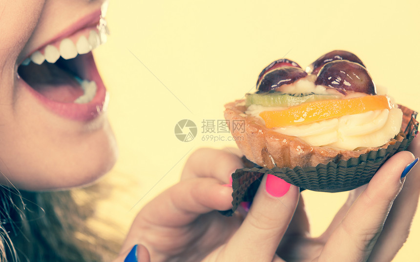甜和快乐的概念近身可爱的卷发美女吃水果蛋糕图片