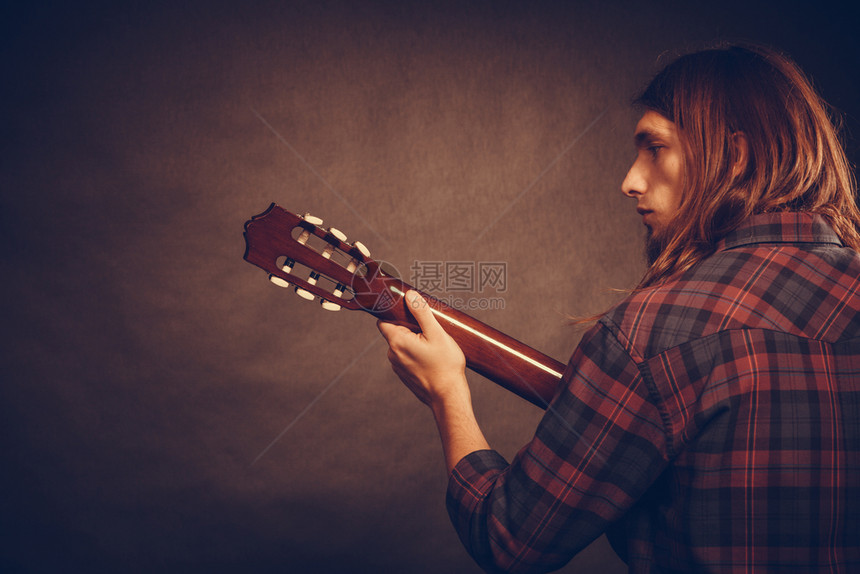 年轻音乐家的后视力男吉他手的后视力音乐声的激情概念年轻音乐家的后视力图片