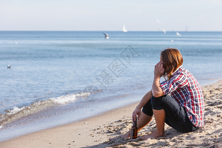 男人在海滩上喝酒背景图片