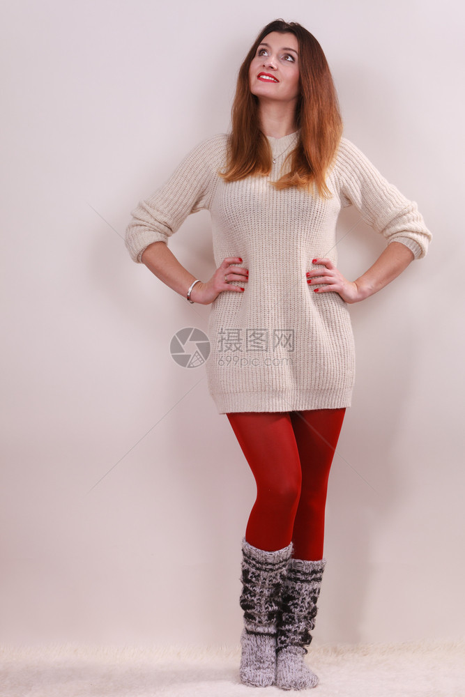 冬时满身穿着冬服装的快乐年轻女子穿着时装的冬季穿着温暖的毛衣袜子和红色的紧身衣服图片