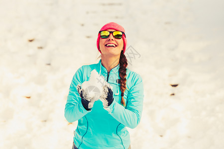 年轻女持雪冬季公园放松乐趣健康自然时装身概念图片