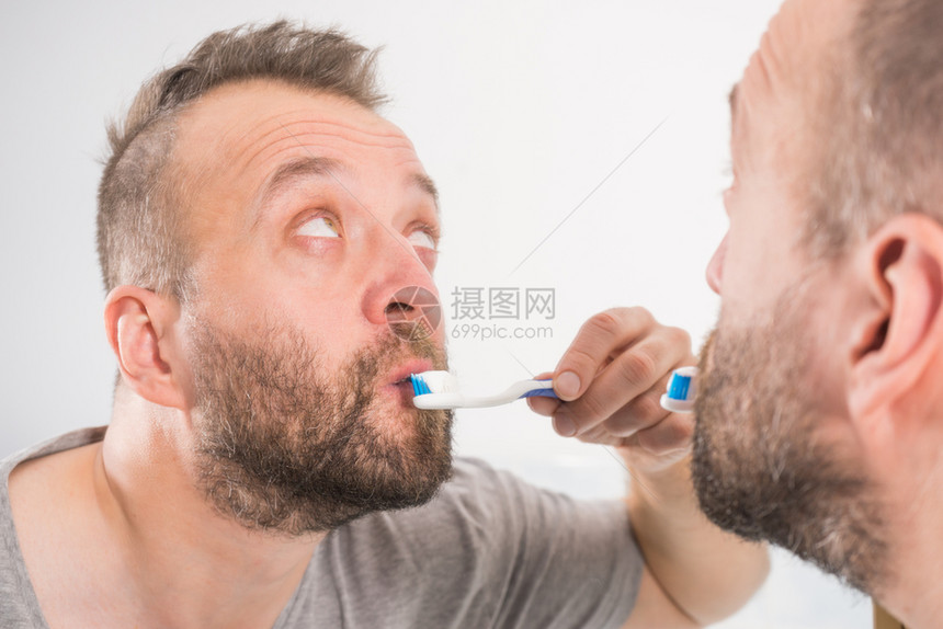 照顾口腔卫生清晨洗手间例行工作时刷牙的人在洗手间刷牙图片